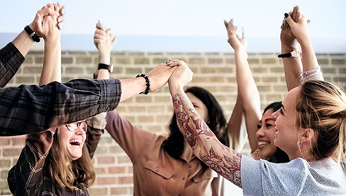 group of people holding their hands up celebrating